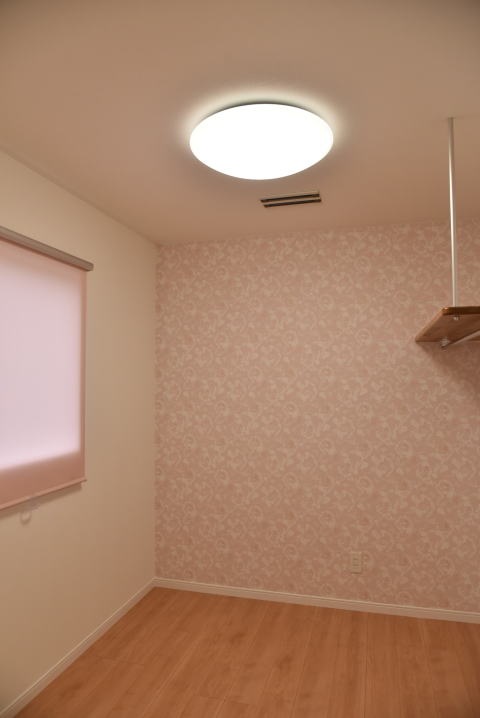 ピンクのアクセント壁の洋室