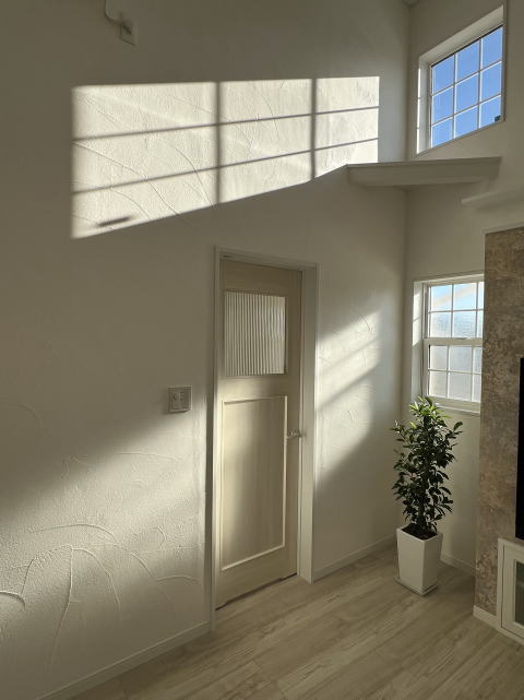 格子窓からの光が差し込む白い漆喰塗り壁